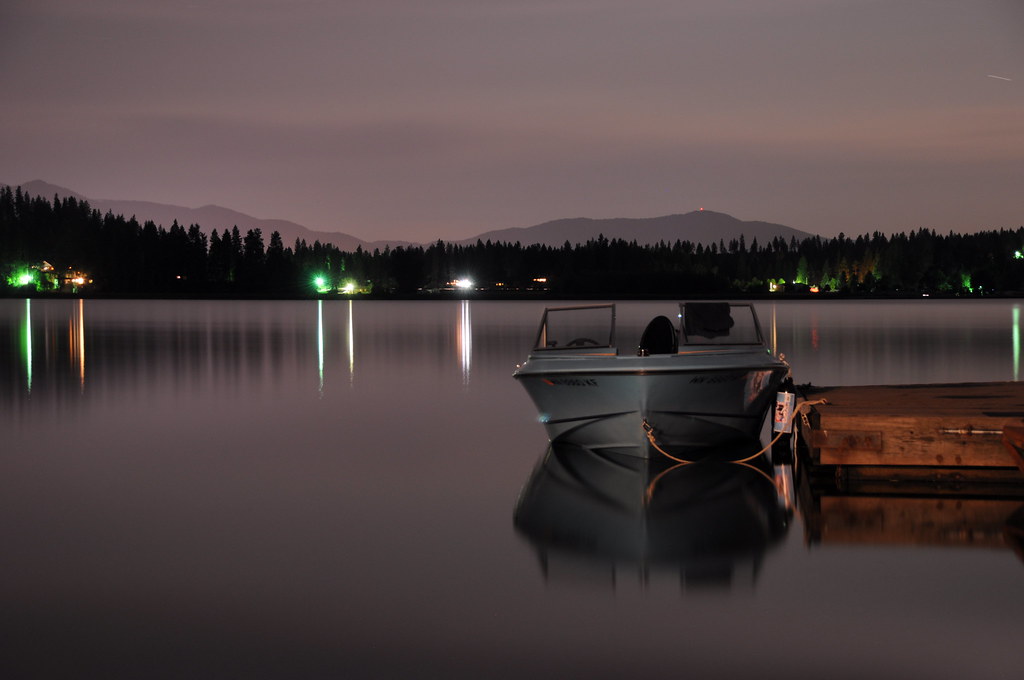 A boat moored on calm Hauser Lake at dusk near Hauser, Idaho.